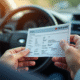 Main tenant une carte grise voiture en plein jour