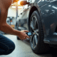 Personne utilisant un manomètre digital sur un pneu de voiture en garage